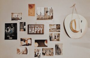 A living room wall decorated with framed pictures and a hat hanging, showcasing an inviting and personal atmosphere.