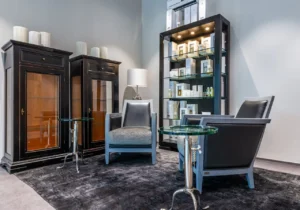 A living room featuring two chairs and a glass cabinet, creating a cozy and inviting atmosphere.